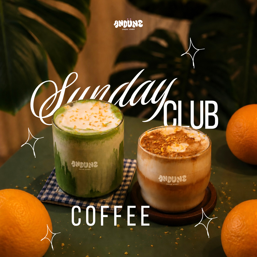 Two iced coffee drinks with whipped cream and toppings sit on a dark green table surrounded by oranges, with large green leaves in the background. White text reads 'Sunday CLUB COFFEE' and 'vendure' appears near the top.